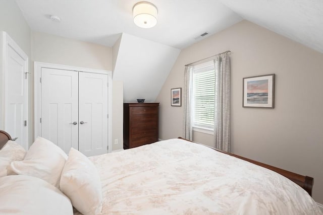 bedroom with lofted ceiling and a closet