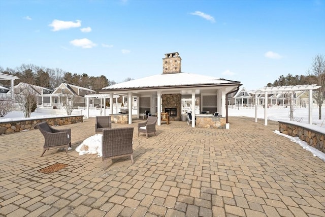 view of patio with a bar, a fireplace, and a pergola