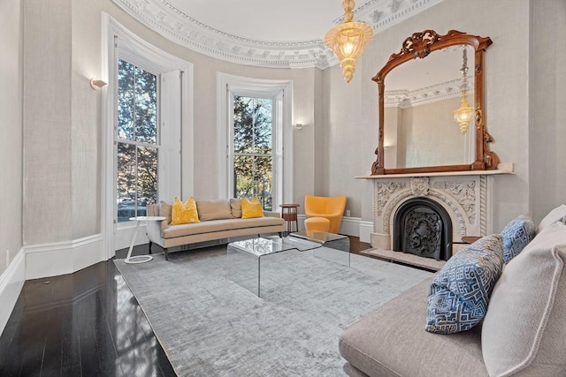 sitting room with crown molding, baseboards, and a fireplace with raised hearth
