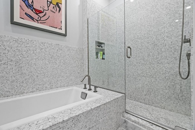 bathroom with a bath and a stall shower