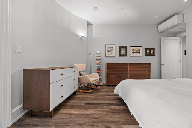 bedroom with baseboards, a wall mounted AC, and dark wood-type flooring