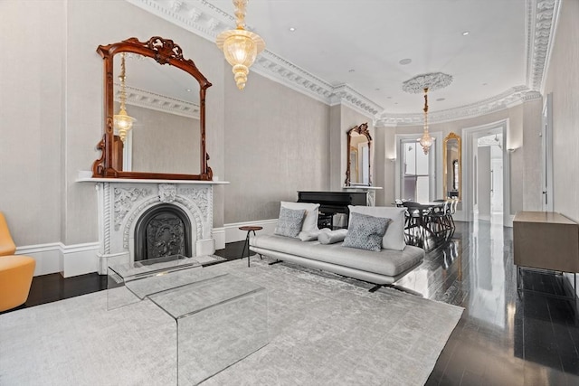living area with ornamental molding, a fireplace with raised hearth, and dark wood finished floors