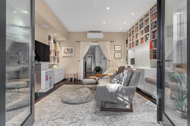 sitting room featuring recessed lighting, a wall mounted AC, built in shelves, and wood finished floors