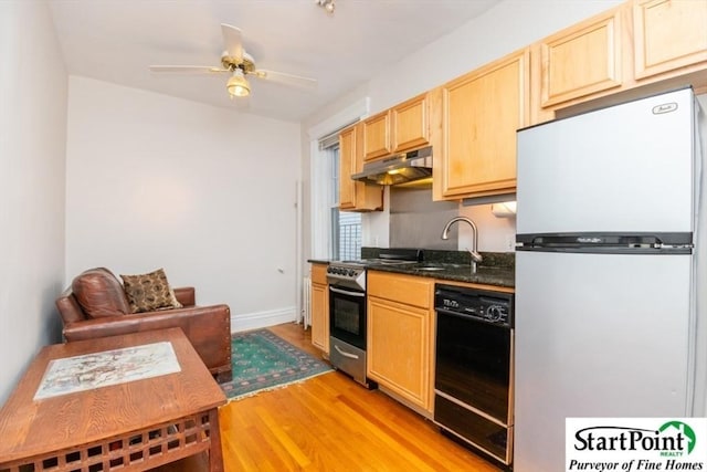 kitchen with black dishwasher, stainless steel gas range oven, freestanding refrigerator, light brown cabinetry, and under cabinet range hood