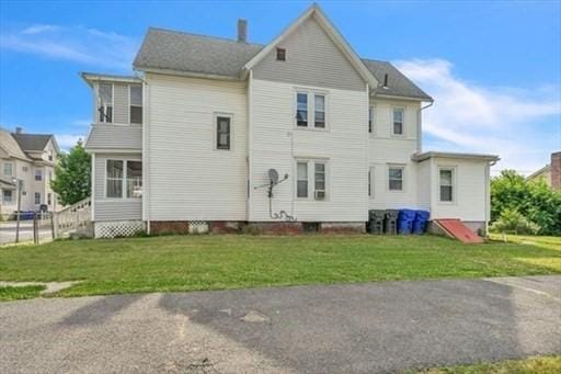 rear view of property with a yard