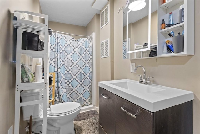 bathroom featuring toilet, a shower stall, and vanity