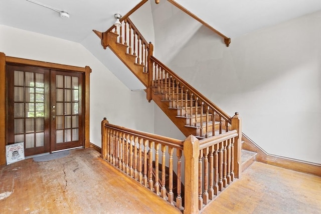 stairway featuring french doors, baseboards, and wood finished floors