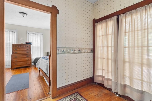 bedroom featuring wallpapered walls and wood-type flooring