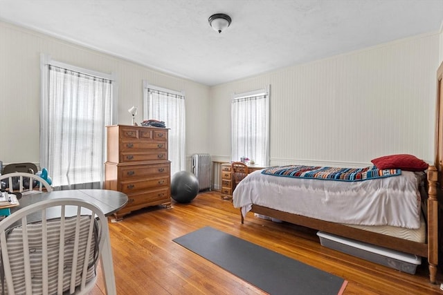 bedroom with radiator and light wood-style flooring