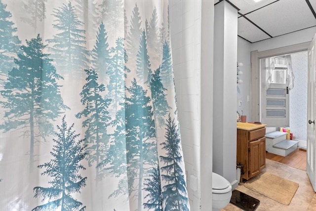 full bath with toilet, a shower with shower curtain, vanity, wood finished floors, and baseboards