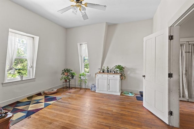 empty room featuring wood finished floors, ceiling fan, and baseboards