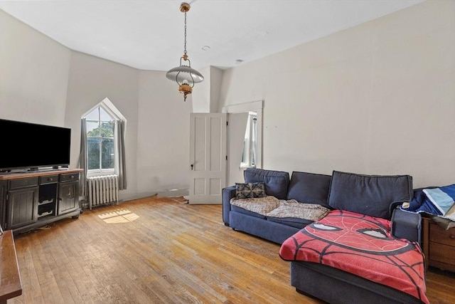 living room with radiator, hardwood / wood-style floors, and a high ceiling