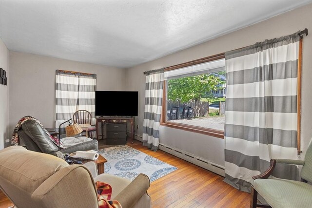 living room featuring baseboard heating and hardwood / wood-style floors