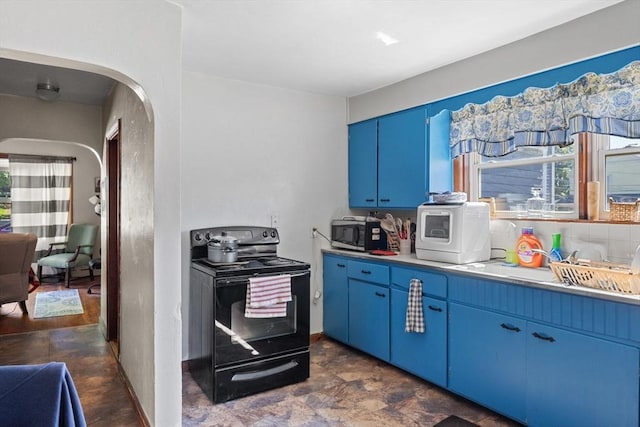 kitchen featuring black electric range, blue cabinetry, stainless steel microwave, and healthy amount of natural light