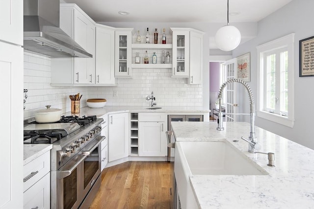 49 Prince St Unit 2, Boston, MA 02130 - kitchen featuring wall chimney exhaust hood, double oven range, open shelves, a sink, and white cabinets