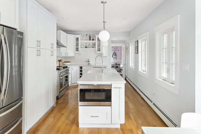 49 Prince St Unit 2, Boston, MA 02130 - kitchen featuring stainless steel appliances, baseboard heating, glass insert cabinets, white cabinetry, and backsplash