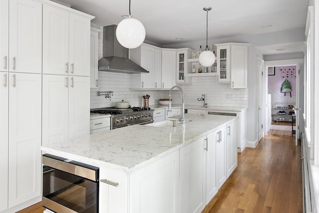 49 Prince St Unit 2, Boston, MA 02130 - kitchen featuring appliances with stainless steel finishes, wall chimney range hood, glass insert cabinets, and backsplash