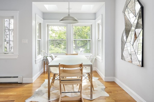 49 Prince St Unit 2, Boston, MA 02130 - dining space featuring baseboard heating, light wood finished floors, baseboards, and a skylight