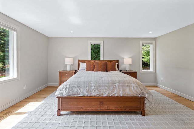 bedroom with light hardwood / wood-style flooring and multiple windows