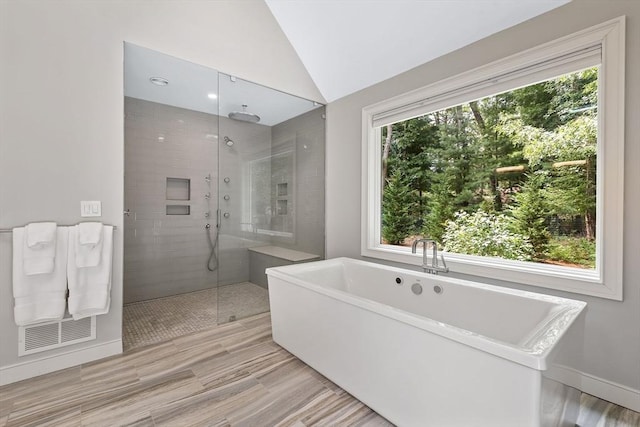 bathroom featuring separate shower and tub and lofted ceiling