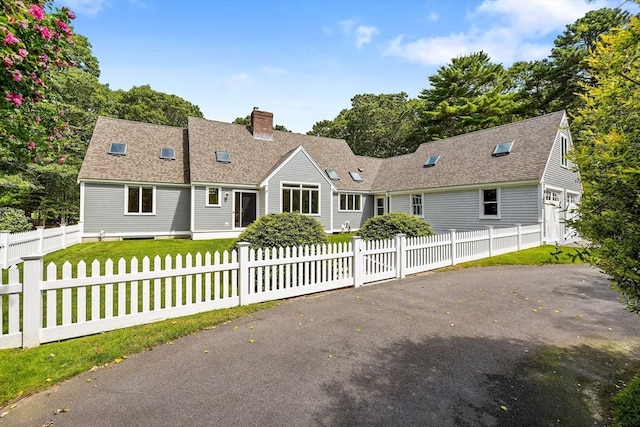 cape cod home with a front lawn