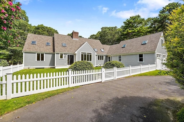 cape cod house featuring a front lawn