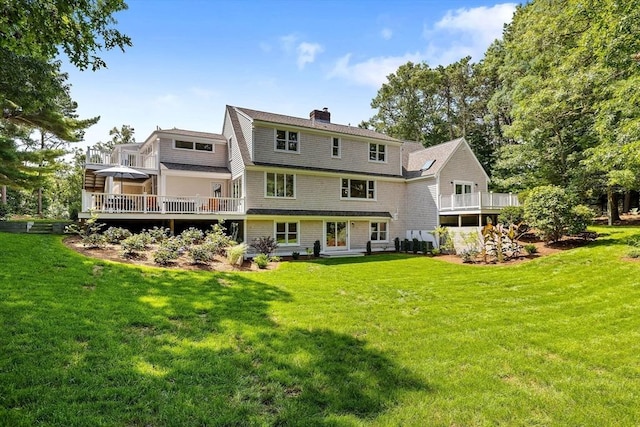 back of house with a wooden deck and a lawn