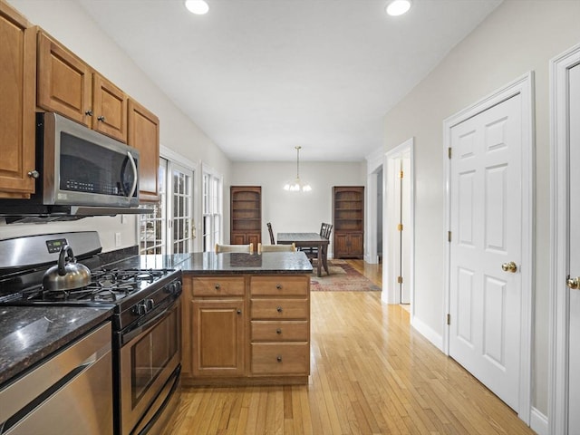 36 Knowlton Cir Unit 36, Upton, MA 01568 - kitchen with stainless steel appliances, a peninsula, brown cabinets, light wood-type flooring, and a chandelier