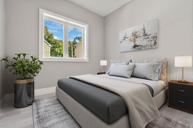 bedroom featuring light wood-style flooring and baseboards