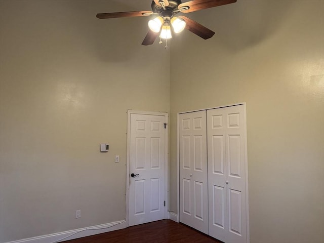 unfurnished bedroom featuring ceiling fan, a closet, and dark hardwood / wood-style floors