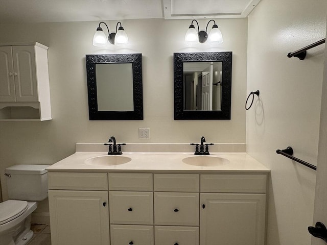 bathroom with toilet, vanity, and tile patterned flooring