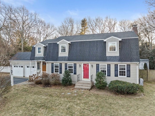 cape cod-style house featuring a garage and a front yard