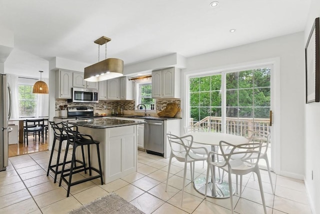 507 Towne St, North Attleboro, MA 02760 - kitchen with stainless steel appliances, dark countertops, a sink, tasteful backsplash, and a kitchen breakfast bar