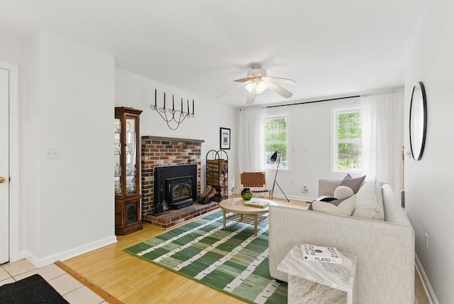507 Towne St, North Attleboro, MA 02760 - living area featuring ceiling fan, baseboards, a wood stove, and light tile patterned floors