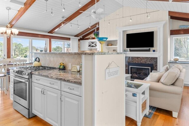 160 Waterway, Mashpee, MA 02649 - kitchen featuring stainless steel gas range, light wood-style flooring, open floor plan, light stone counters, and a fireplace