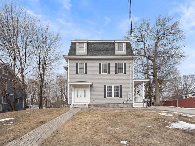 second empire-style home with covered porch and roof with shingles