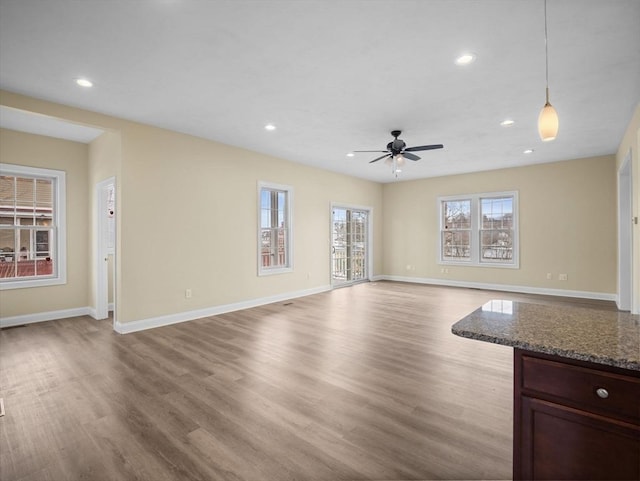 unfurnished living room featuring a ceiling fan, recessed lighting, light wood-style flooring, and baseboards