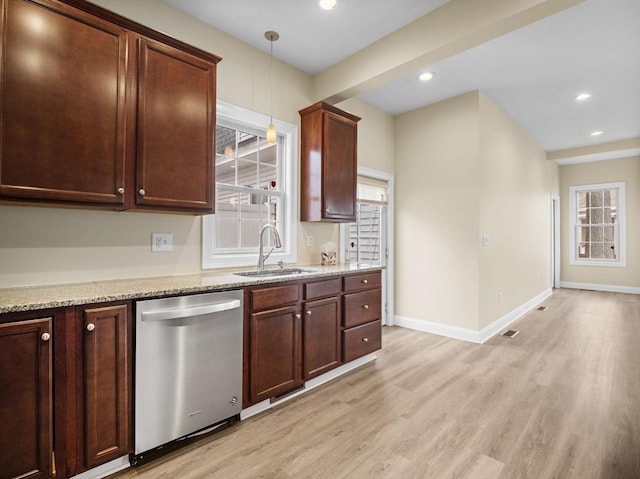 kitchen with hanging light fixtures, light wood-style flooring, stainless steel dishwasher, a sink, and light stone countertops