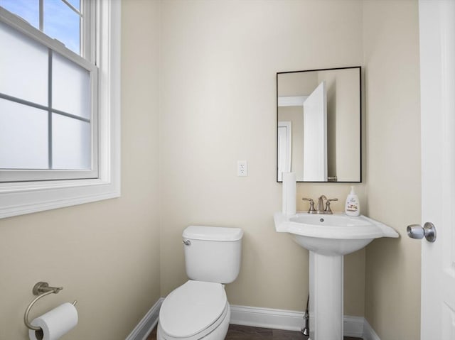 half bath with toilet and baseboards