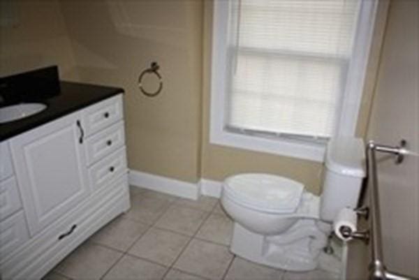 bathroom featuring toilet, tile patterned floors, baseboards, and vanity