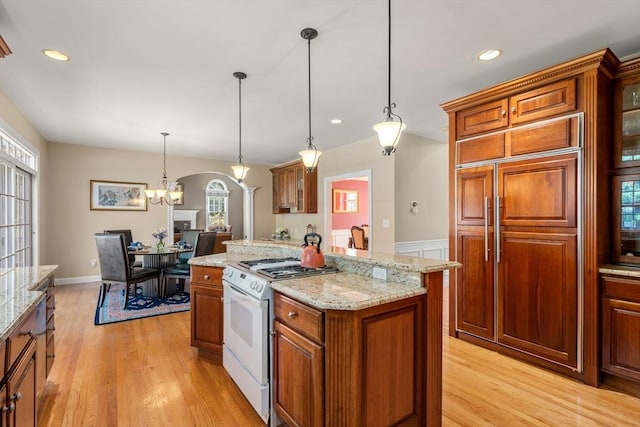 20 Peakham Rd, Sudbury, MA 01776 - kitchen with paneled built in fridge, arched walkways, gas range gas stove, and light wood finished floors