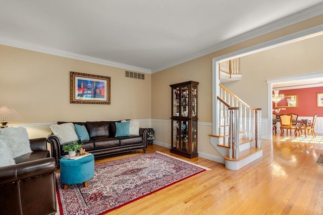 20 Peakham Rd, Sudbury, MA 01776 - living area with visible vents, wood finished floors, an inviting chandelier, ornamental molding, and stairs