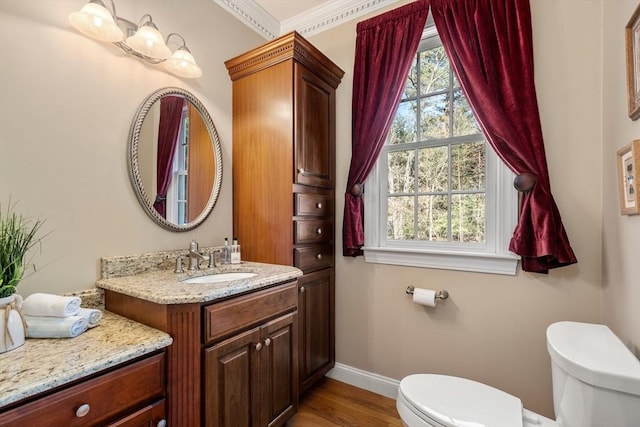 20 Peakham Rd, Sudbury, MA 01776 - half bathroom featuring vanity, toilet, baseboards, wood finished floors, and ornamental molding