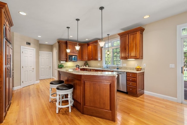 20 Peakham Rd, Sudbury, MA 01776 - kitchen with appliances with stainless steel finishes, baseboards, brown cabinetry, and light wood finished floors