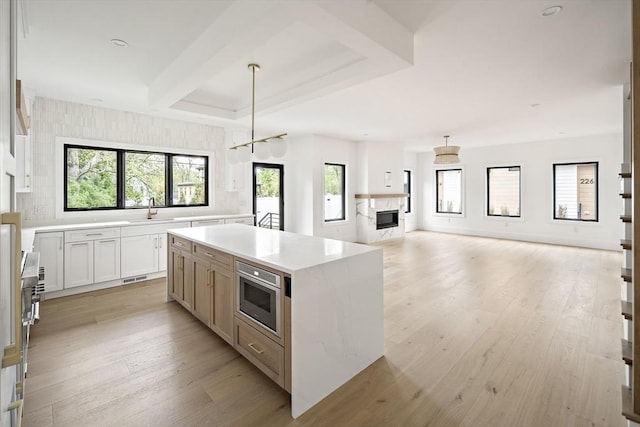 228 Auburn St Unit 228, Newton, MA 02466 - kitchen with a center island, light countertops, healthy amount of natural light, and light wood-type flooring
