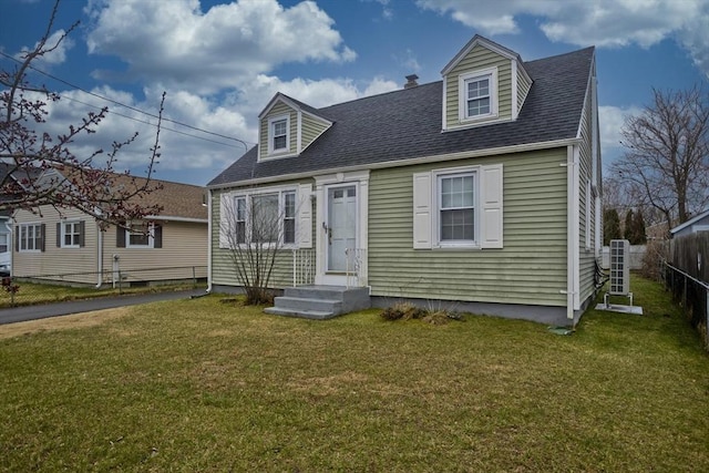 cape cod home featuring entry steps, a front lawn, fence, and roof with shingles