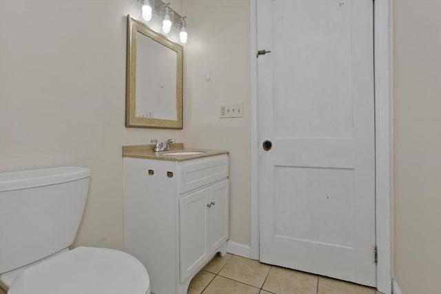bathroom with toilet, tile patterned flooring, and vanity
