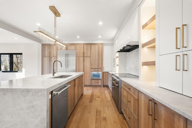 kitchen with a large island with sink, white cabinetry, hanging light fixtures, premium appliances, and custom range hood