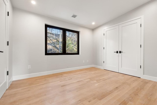 unfurnished bedroom with a closet and light wood-type flooring