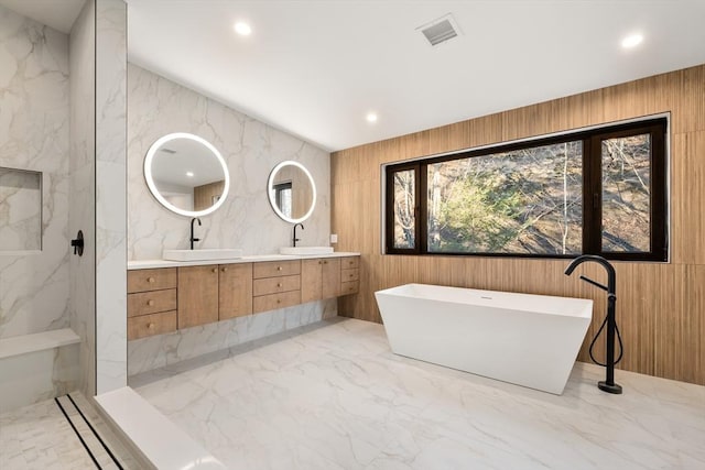 bathroom featuring vanity, a bathing tub, and wooden walls